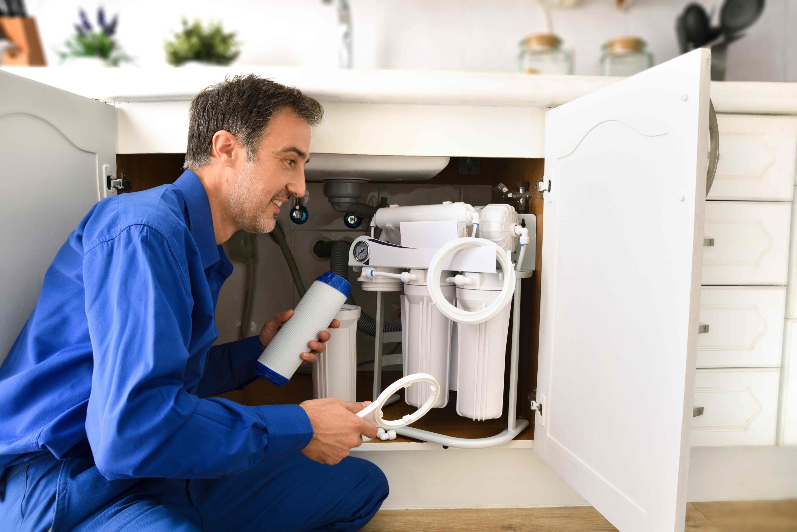 Technician installing reverse osmosis equipment under the sink. Front view. Horizontal composition. — Photo